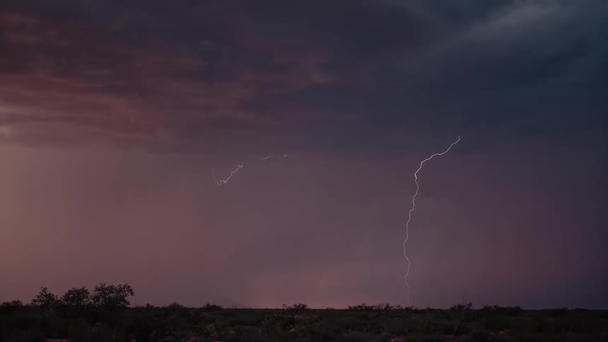 Lightning flashes through the clouds at sunset