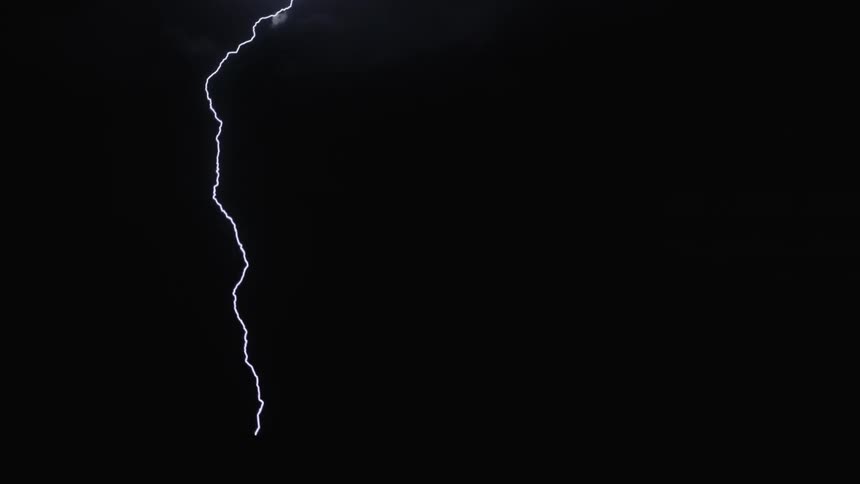 A lightning bolt lighting up the dark night sky creating streaks across the clouds