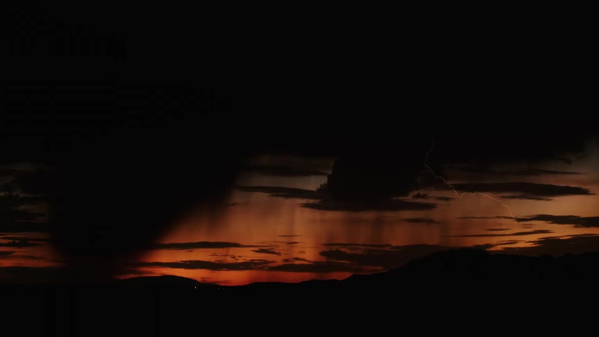 A lightning storm in a dark sky with orange light