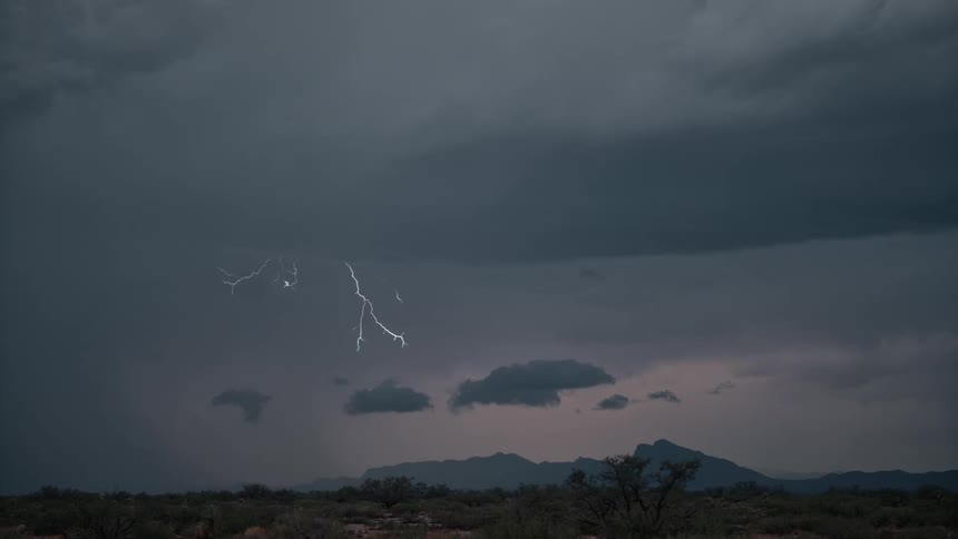 Cloudy sky with white lightning and thunder at sunset