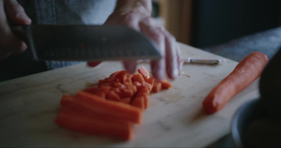 A person is cutting carrots at home