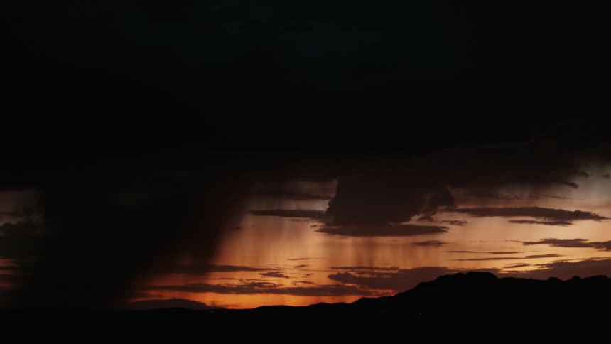 A lightning storm over a mountain range at sunset