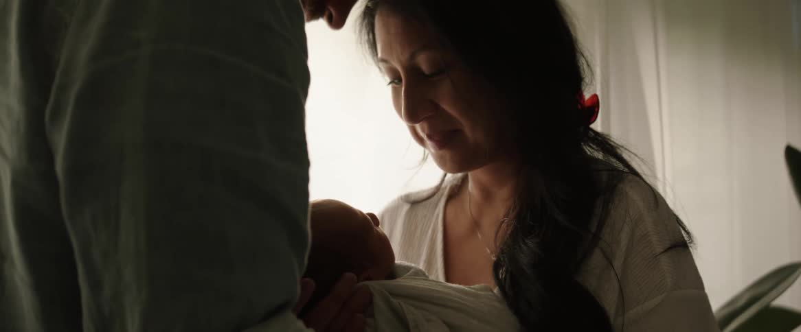 Happy couple lovingly looking at their baby