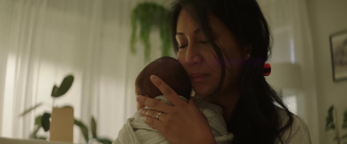 A mother holds and sways with her infant child