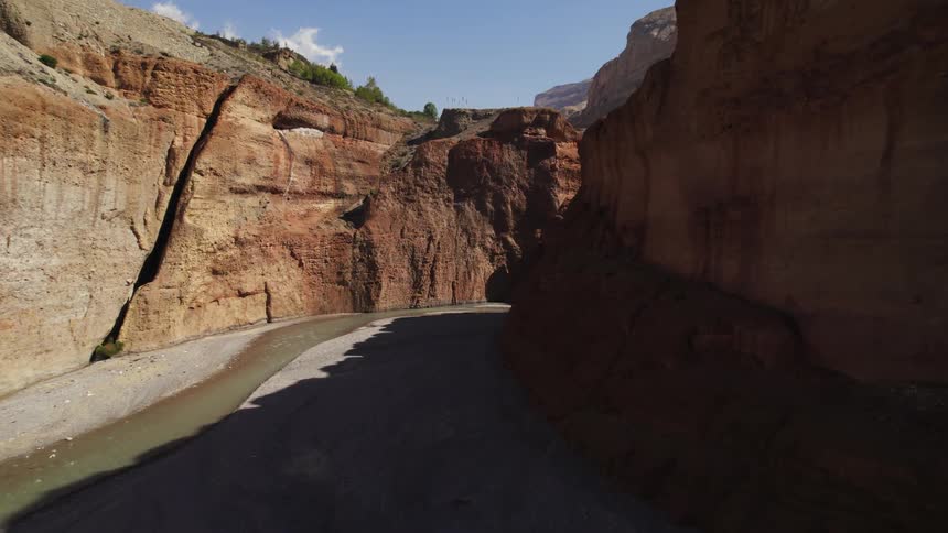 In the canyon a stream of water carves a path through the rocks adding a serene and beautiful touch to the rugged landscape