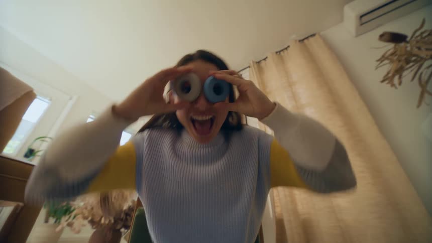 Woman putting two balls on her eyes and smiling and joking in front of the camera