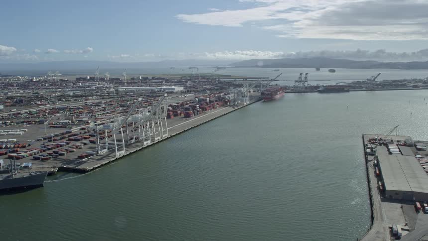  aerial footage capturing cargo cranes and containers at the Port of Oakland California on a partly cloudy day