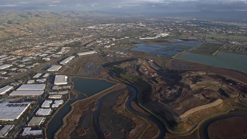  aerial footage showcasing the stunning Fremont marshland and nearby industrial warehouses on a partly cloudy day in Northern California's Bay Area