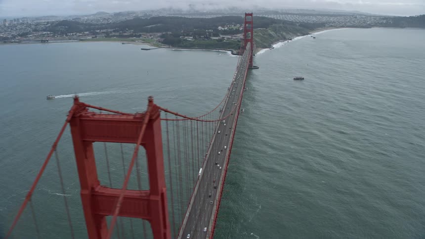  aerial footage of traffic traveling along the iconic Golden Gate Bridge on a foggy day in San Francisco California