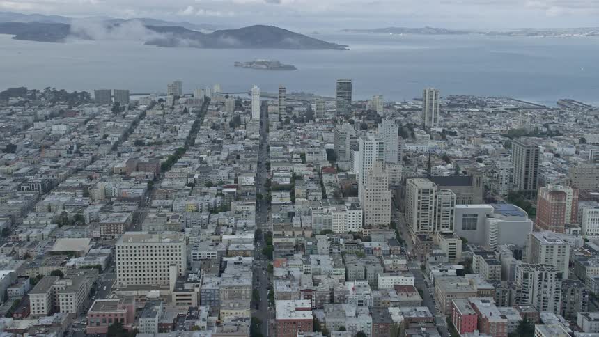 Aerial footage of San Francisco's iconic Nob Hill apartment buildings and a view of Alcatraz Island during a cloudy day