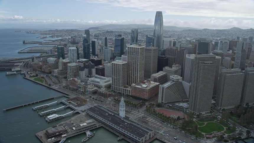 Reverse aerial view of Downtown San Francisco with cloudy skies showcasing the high-rise skyscrapers and cityscape of this iconic Northern California destination during the day