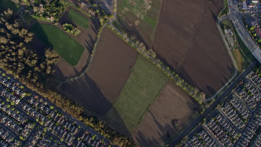  aerial footage showcasing a bird's eye view of Union City tract homes in California surrounded by flat fields and intersecting highways