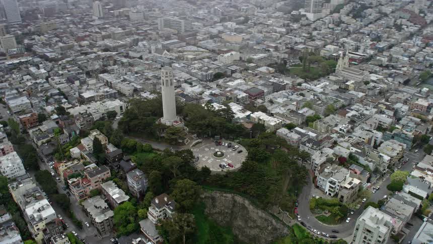  aerial footage showcasing the approach and flyby of Coit Tower in San Francisco California on a sunny day with a side view perspective