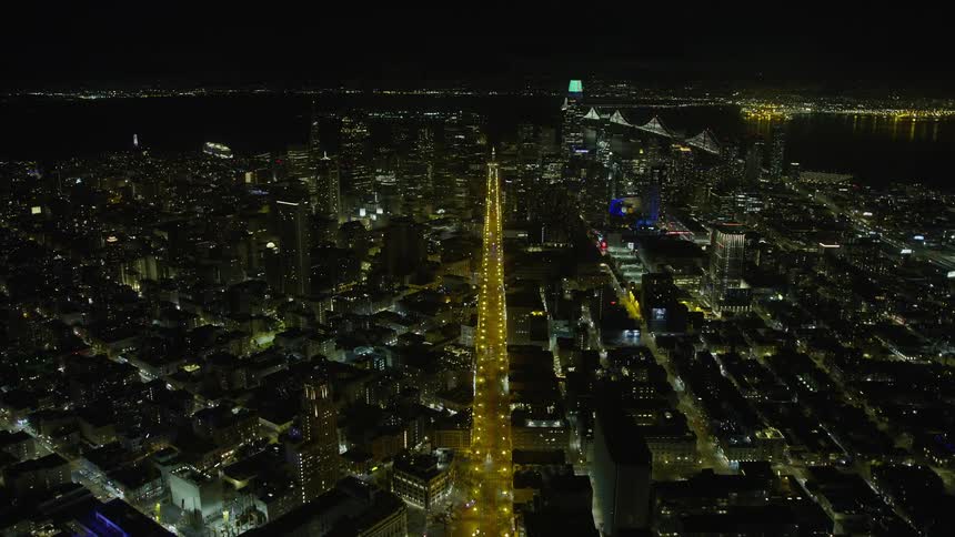  aerial footage flying over Market Street towards Downtown San Francisco at night showcasing the high rise towers and clear skies of the city