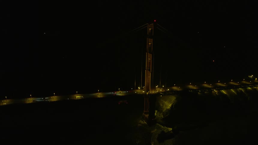 A stunningaerial flyby of the iconic Golden Gate Bridge at night showcasing the clear skies light traffic and the historic landmark in Northern California