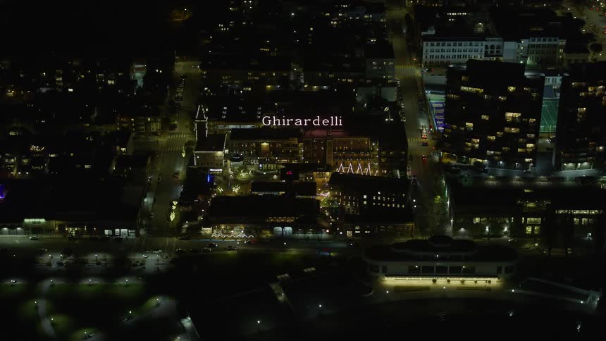 aerial footage of Ghirardelli Square at night showcasing the historic landmark and the bustling retail center of San Francisco California with clear skies overlooking the iconic structure and cityscape on the west coast