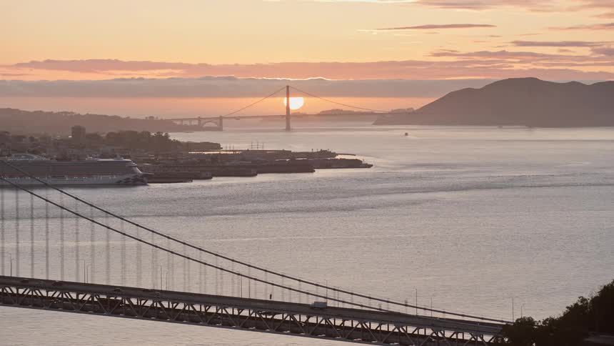 aerial stock footage showcasing the iconic Golden Gate Bridge and an sunset over the San Francisco Bay captured from the Bay Bridge in California's Bay Area