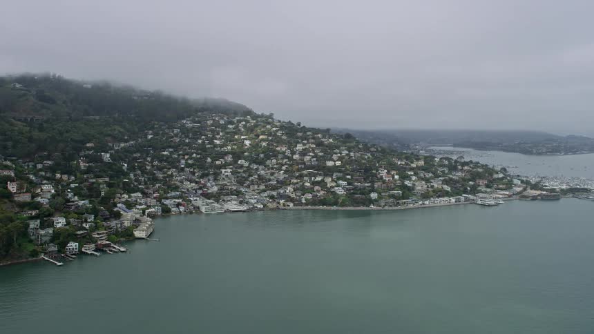 Aerial footage of homes overlooking the foggy bay in Sausalito on a summer day in California