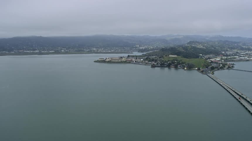  aerial footage of an overcast day as we approach San Quentin Prison from the Richmond Bridge in Northern California's Bay Area during summer