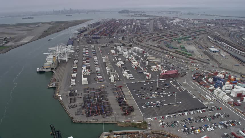  aerial footage showcasing shipping containers at the Port of Oakland California on a foggy day in the bay area providing a side view of the bustling maritime and shipping industry in Northern California during spring or summer
