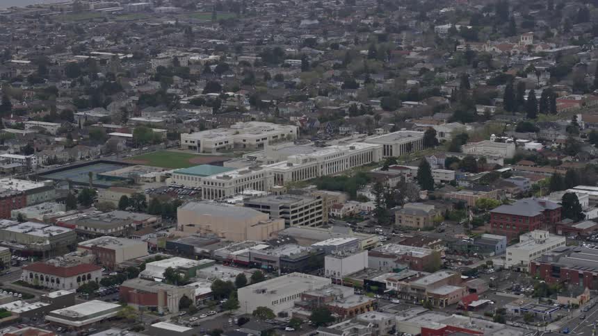 Aerial footage of a theater and high school in Alameda California during a misty day showcasing the enjoyment and learning in this city