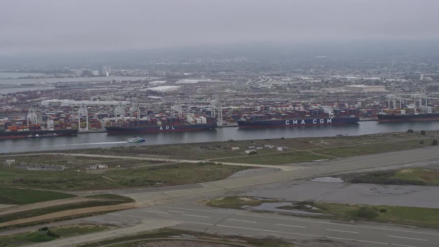 Aerial footage of cargo ships docked at the Port of Oakland California on a cloudy day