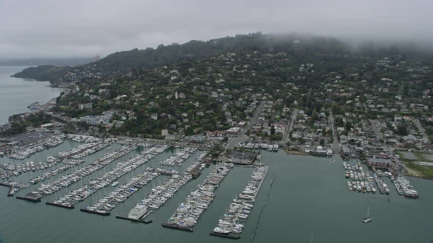 Aerial footage of foggy day in Sausalito California showing residential neighborhoods marinas and shoreline