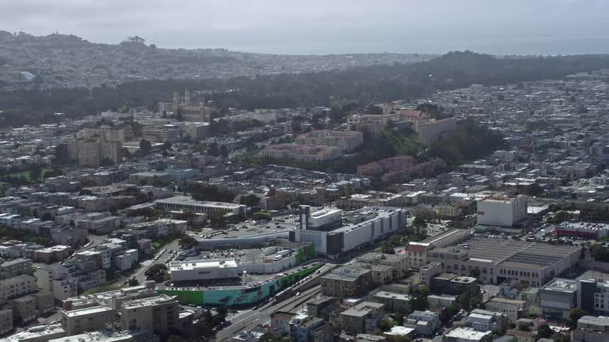  aerial footage capturing USF Lone Mountain in the Inner Richmond district of San Francisco California showcasing the city during a partly cloudy day with a side view of the college campus