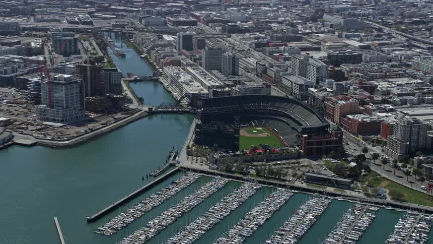 Aerial footage of a sunny baseball stadium overlooking the waterfront of San Francisco California during daytime