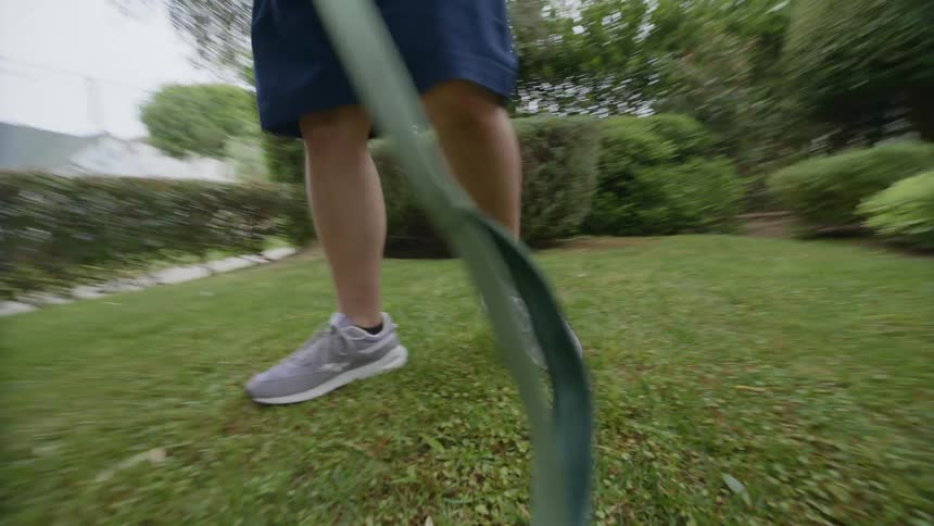 A point of view of an animal that is on a leash and its owner who is a man leads him