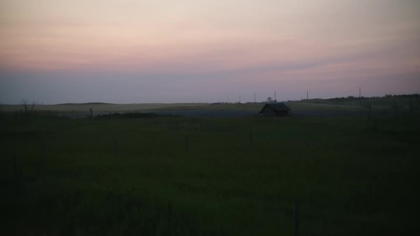 A grassy field and cloudy sky at dawn
