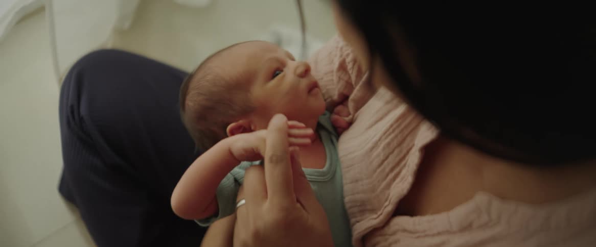 Newborn baby falls asleep on a woman lap at home