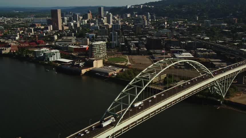 Aerial footage of the Fremont Bridge in Downtown Portland Oregon showcasing the city's high-rise buildings and the Willamette River