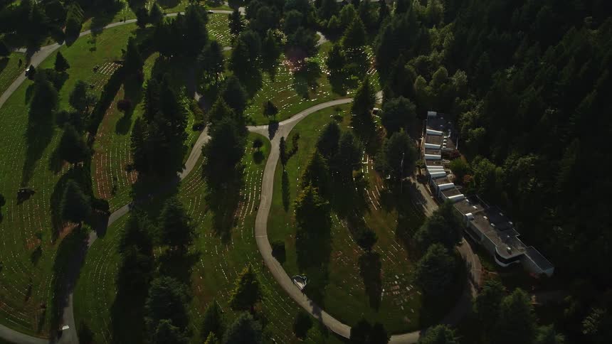 Aerial view of Sunset Hills Memorial Park a serene cemetery in Southwest Portland Oregon surrounded by lush greenery and bathed in golden sunlight
