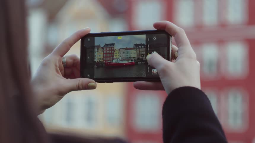 Person taking photo of a red and white boat