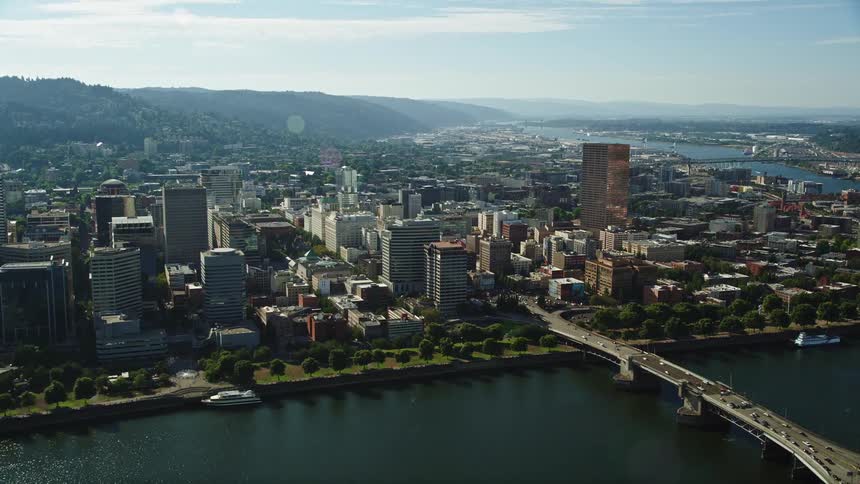 Tilting up from the Marquam Bridge this aerial footage showcases the downtown buildings of Portland Oregon revealing a metropolis along the Willamette River