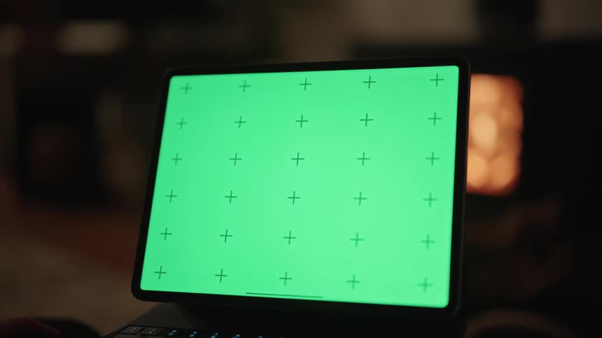 A person is pointing at a computer monitor with a green display