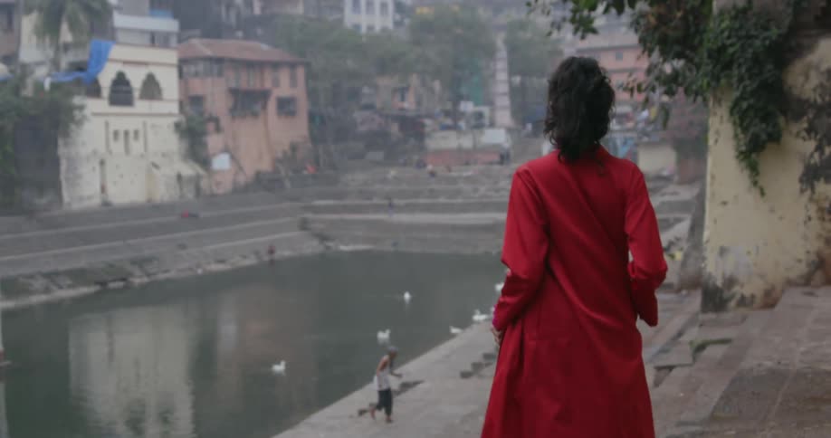 A woman walks down the steps in a city