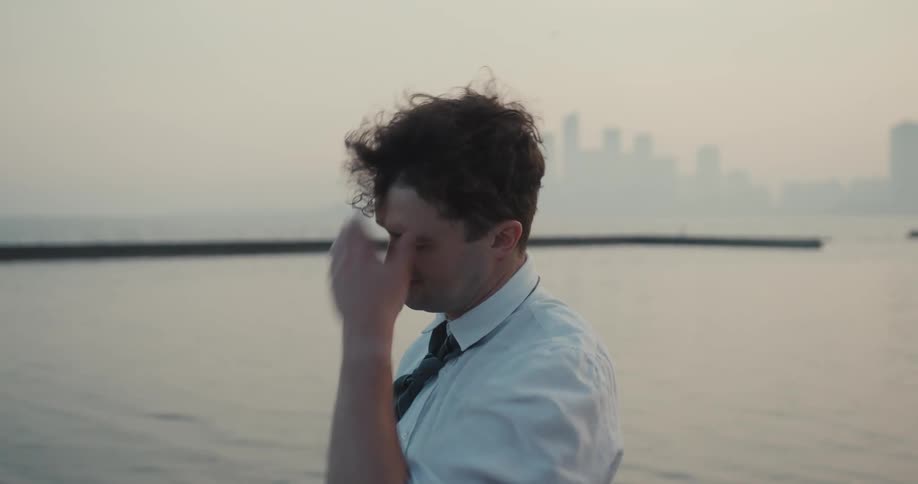 An overwrought businessman contemplates his decisions at the lakeside