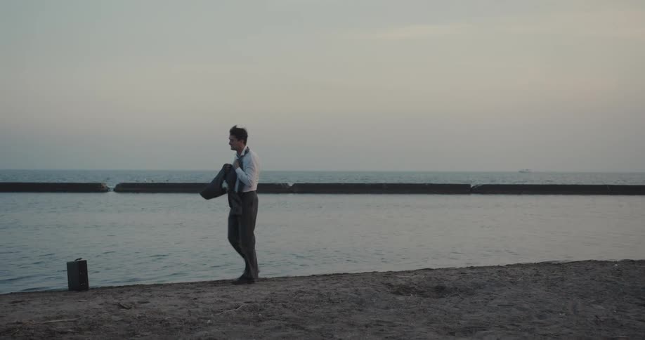 A sad and nervous man walking along the seashore