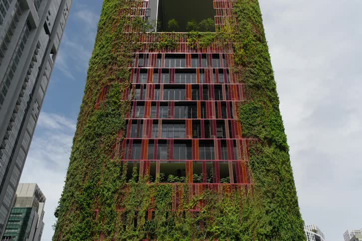 Red building with modern design and plants growing on the walls