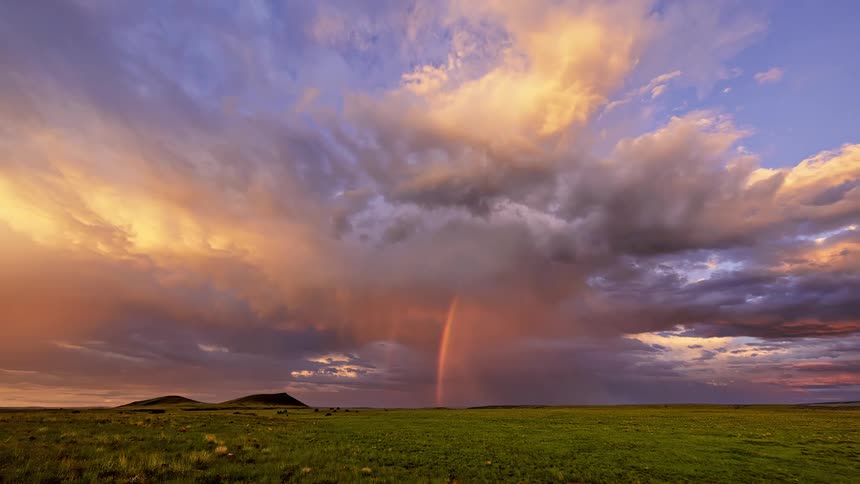 A rainbow is arched into the clouds