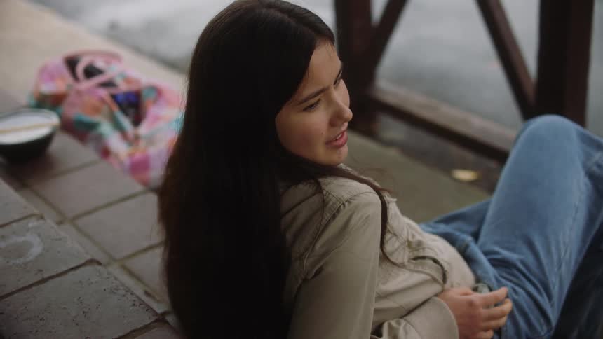 A girl is sitting outside talking