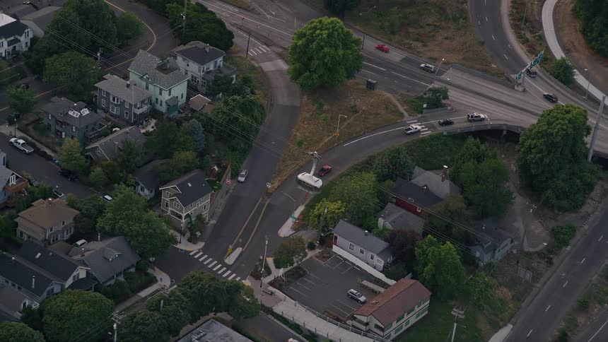 Aerial footage of gondola tracking over I-5 near Oregon Health and Science University Portland Oregon during twilight with partly cloudy skies and light traffic