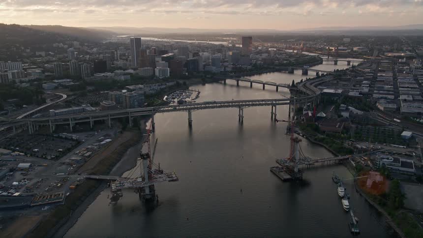 Aerial footage of Downtown Portland at sunset showcasing bridges high rise buildings and the scenic Willamette River