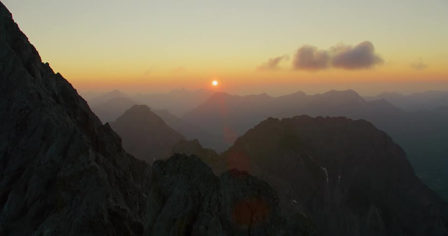 A serene landscape with majestic mountains and a crescent moon shining in the sky in the evening