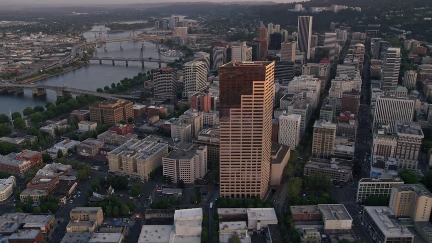  aerial footage of downtown Portland at sunset showcasing the US Bancorp Tower bridges over the Willamette River and the vibrant cityscape