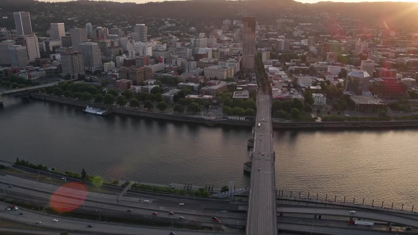 Approaching Burnside Bridge and US Bancorp Tower in downtown Portland Oregon during sunset with a stunning aerial view of the city and river