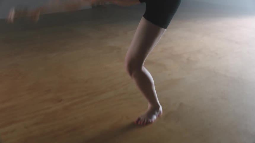 A person practicing dance steps on a light floor