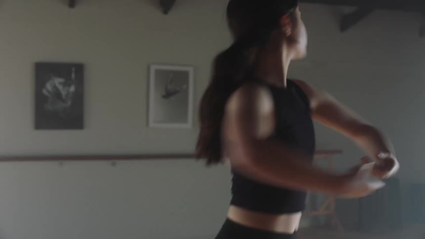 Woman practices dance routine in dance studio
